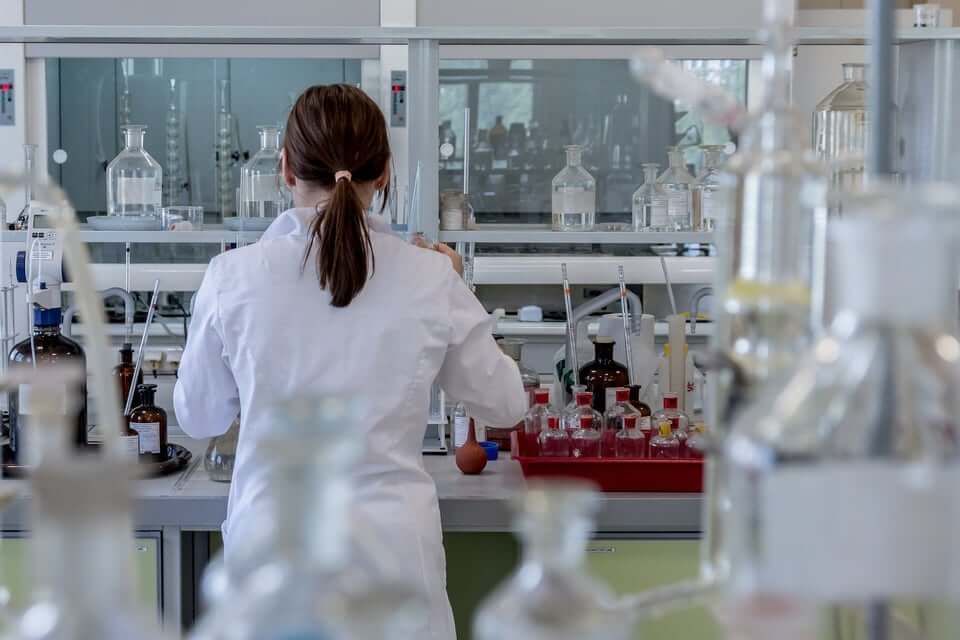 woman in white lab coat working in a lab