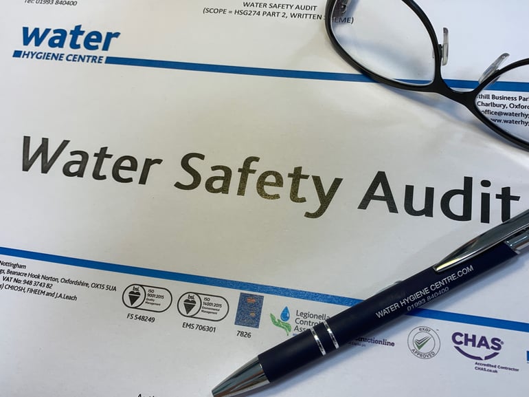 piece of paper with 'Water safety audit' printed on it along side reading glasses and a pen