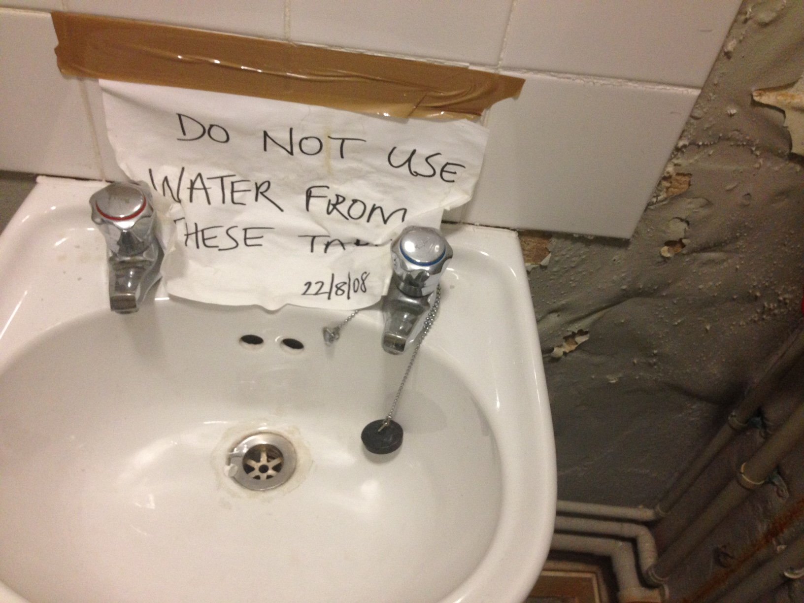 sink with a sign attached to it which a piece of paper saying 'do not use water'