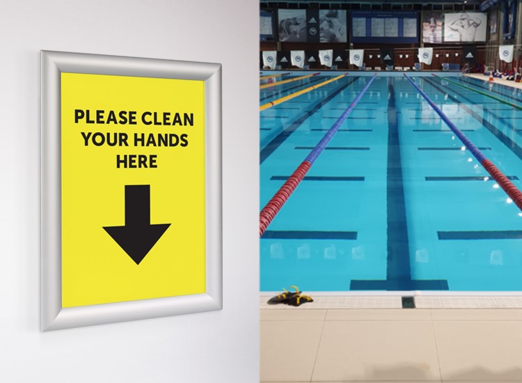 swimming pool with a yellow poster nearby saying 'please clean your hands here'