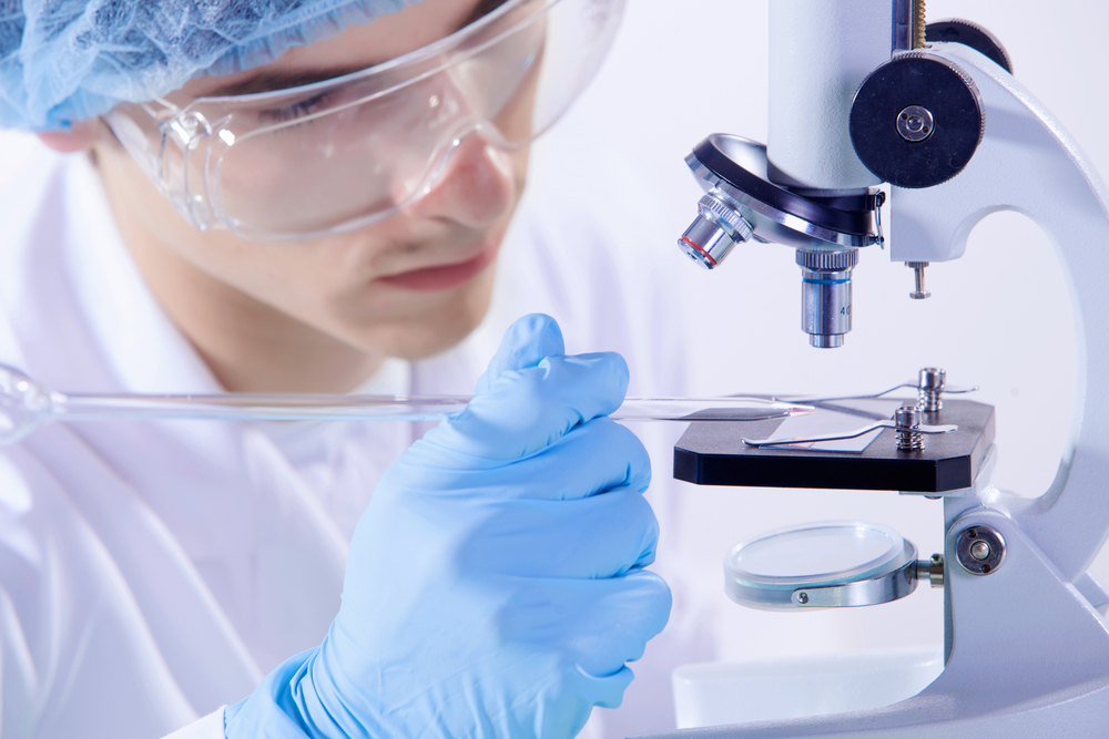 man scientist working in laboratory with microscope