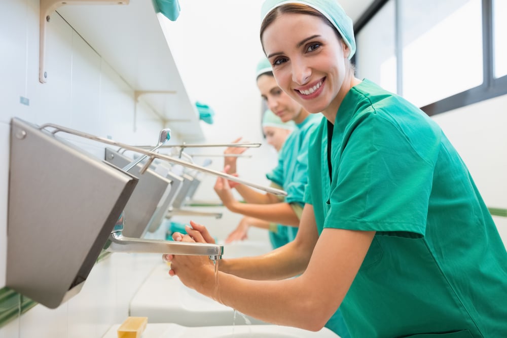 female Surgeons washing their hands in a hospital while smiling